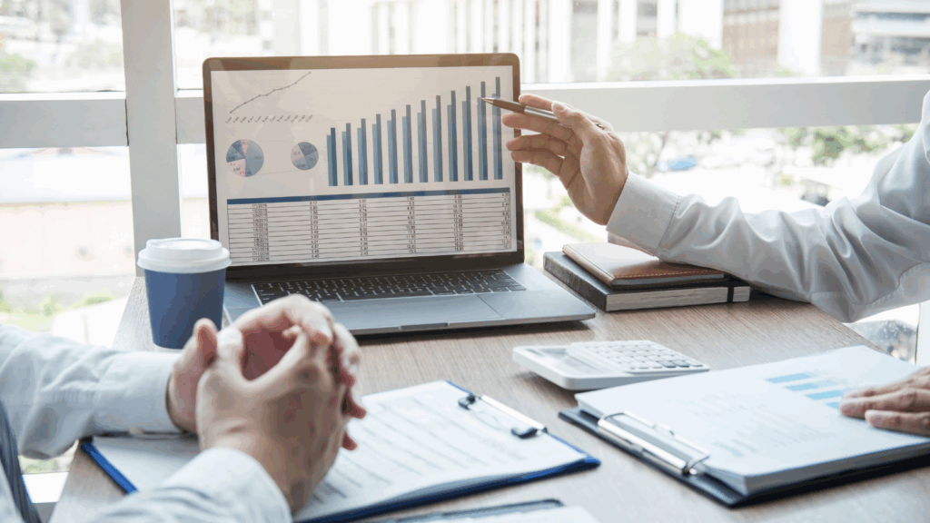 Professional meeting with financial charts on a laptop, documents, and calculator on the desk, symbolizing expert business formation services. The image represents strategic guidance for LLC setup, S-Corp election, EIN registration, and tax structure planning to help entrepreneurs start their businesses correctly.