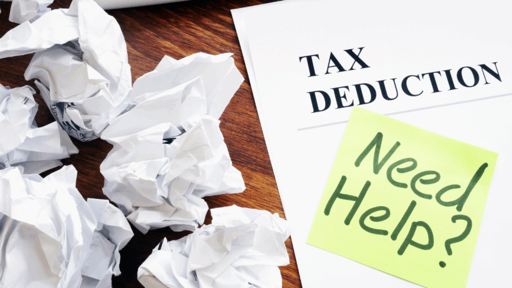 Tax deduction paperwork and a note reading “Need Help?” on a wooden desk, symbolizing confusion around quarterly estimated tax payments. The image represents professional assistance from a small business tax accountant to calculate, plan, and make accurate quarterly estimated tax payments on time.